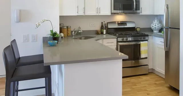 a kitchen with stainless steel appliances a stove a sink a microwave and cabinets