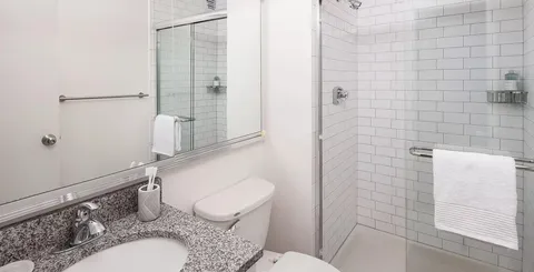 a bathroom with a granite countertop toilet sink and shower