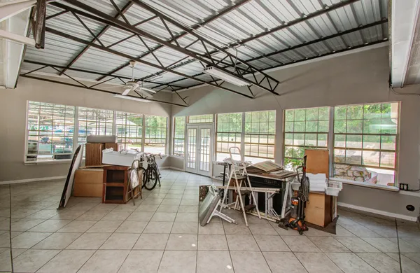 a view of an empty room with window and wooden floor