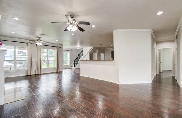 a view of a big room with wooden floor and a kitchen