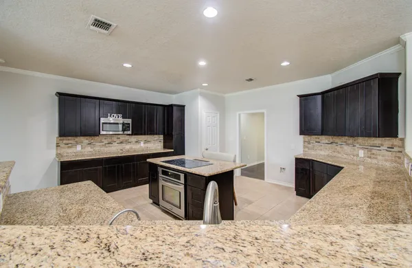 a kitchen with a stove a sink dishwasher and wooden cabinets