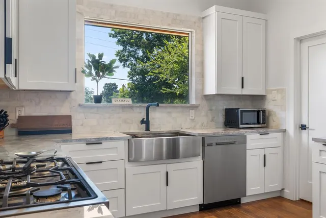 a kitchen with white cabinets a sink and a stove