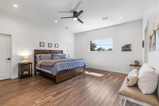 a bedroom with a bed and wooden floor