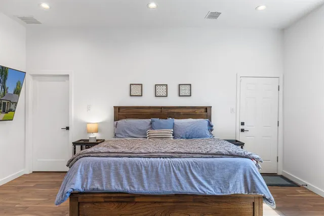 a bedroom with a bed and wooden floor