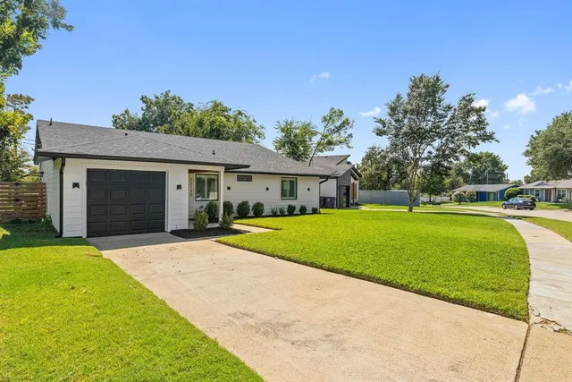 a front view of a house with a garden and trees