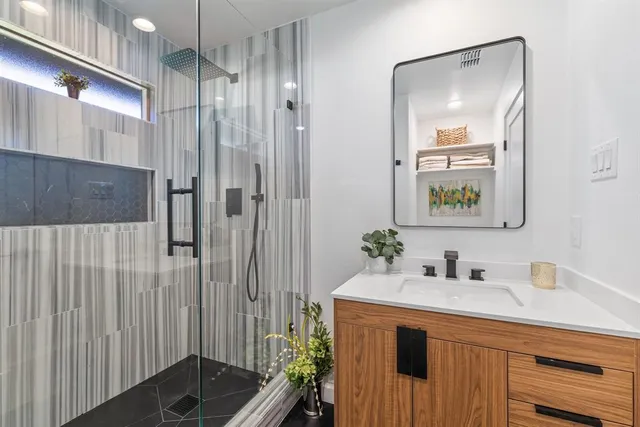 a bathroom with a shower sink and mirror