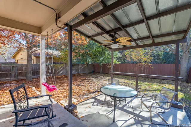 a backyard of a house with fountain table and chairs