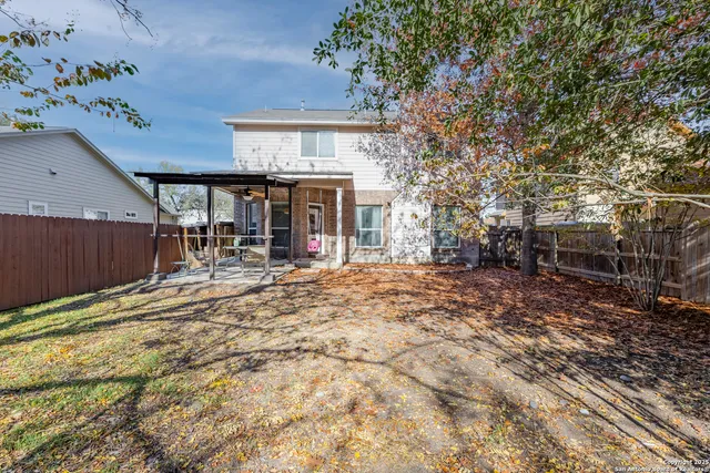 a view of a backyard with table and chairs and wooden fence