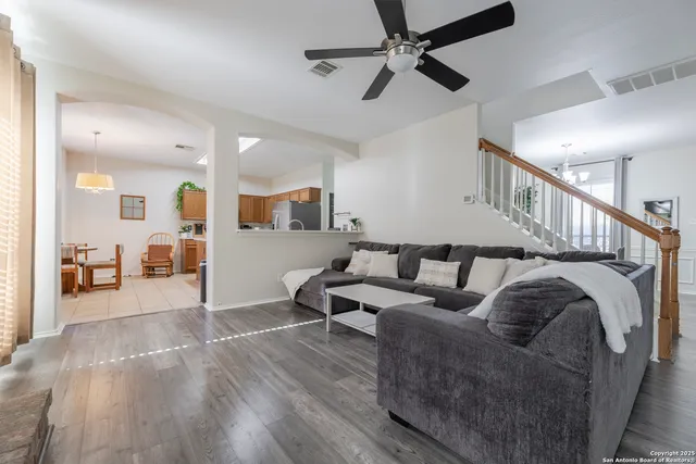 a living room with furniture and a wooden floor