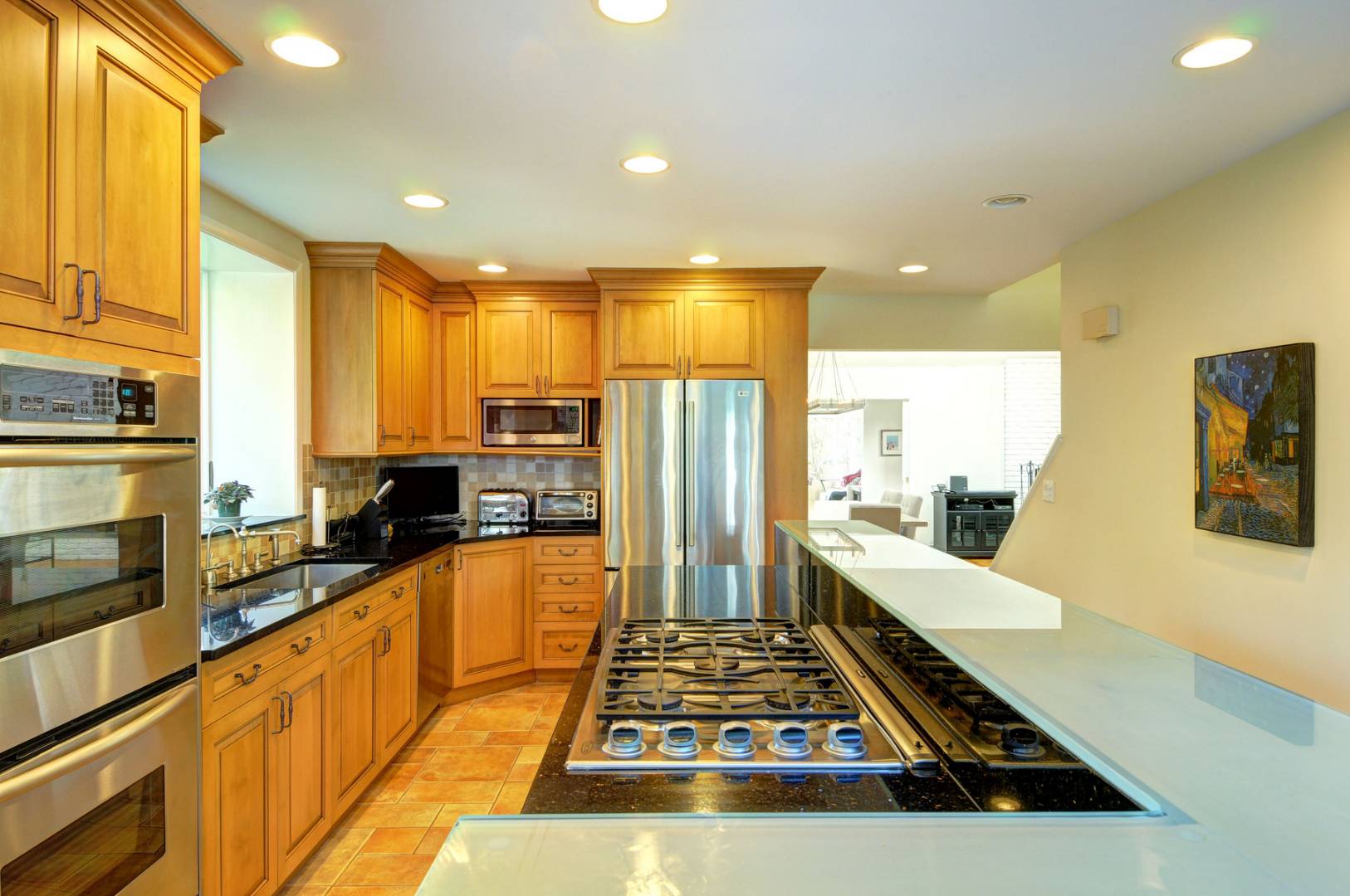 120 Springy Banks Road East Hampton, NY 11937 - Photo 5 of 10 a large kitchen with stainless steel appliances a stove a refrigerator a sink a dining table and chairs with wooden floor