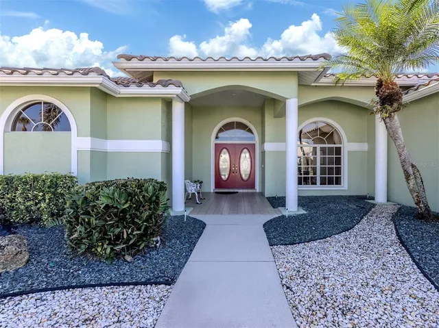 a kitchen with stainless steel appliances kitchen island granite countertop a refrigerator a sink a stove and white cabinets