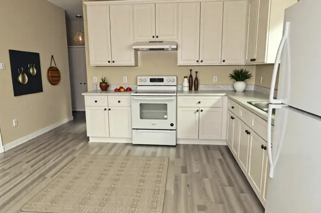 a kitchen with granite countertop white cabinets and white appliances
