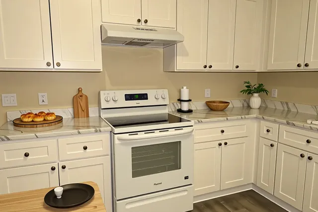 a kitchen with appliances cabinets and a stove top oven
