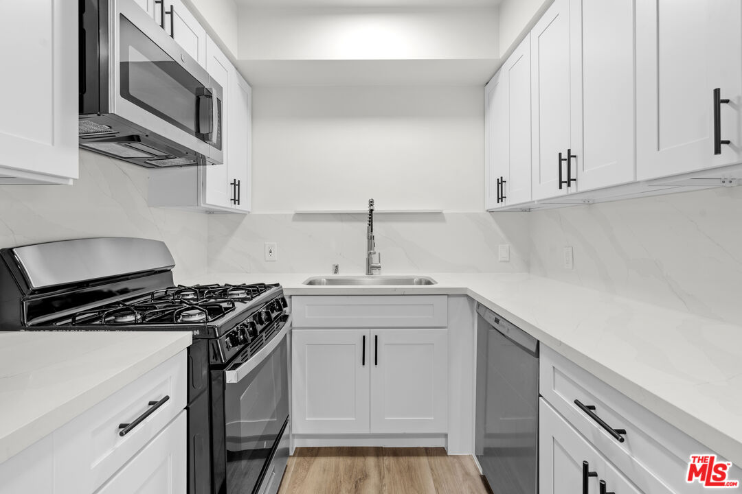 7825 West Manchester Avenue, Unit 28 Playa del Rey, CA 90293 - Photo 7 of 14 a kitchen with stainless steel appliances a sink stove and cabinets