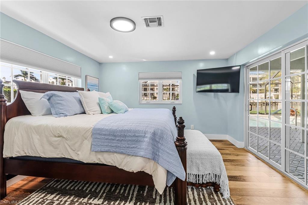 1823 Hurricane Harbor Lane Naples, FL 34102 - Photo 16 of 30 a bedroom with a large bed and a tv