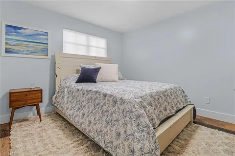 a bedroom with a bed and a chair with rug