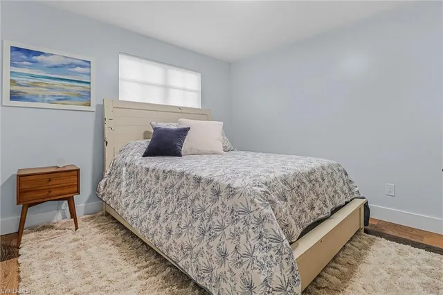 a bedroom with a bed and a chair with rug