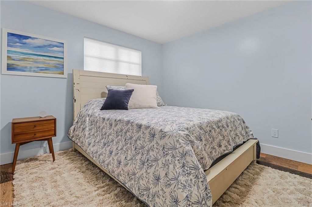 1823 Hurricane Harbor Lane Naples, FL 34102 - Photo 20 of 30 a bedroom with a bed and a chair with rug