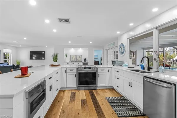 a large kitchen with stainless steel appliances kitchen island granite countertop a sink and cabinets