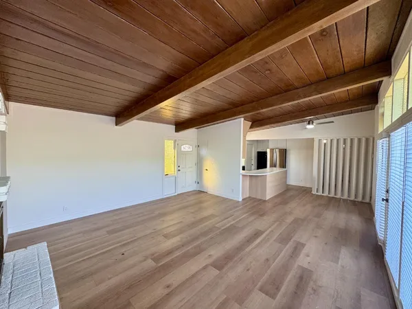 a view of empty room with wooden floor