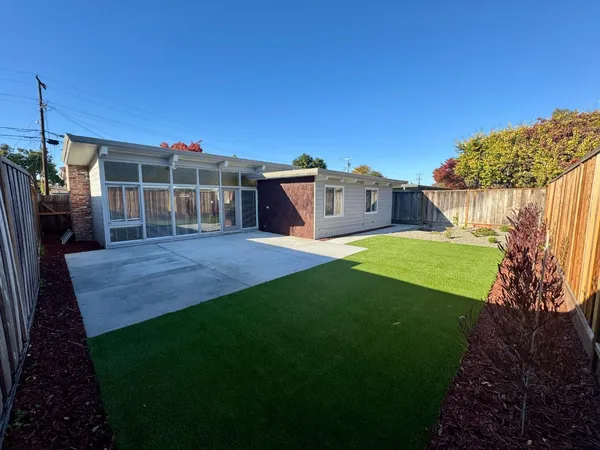 a view of a house with a yard deck and a table