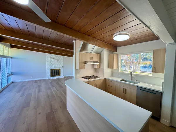 a view of a kitchen with a sink and wooden floor