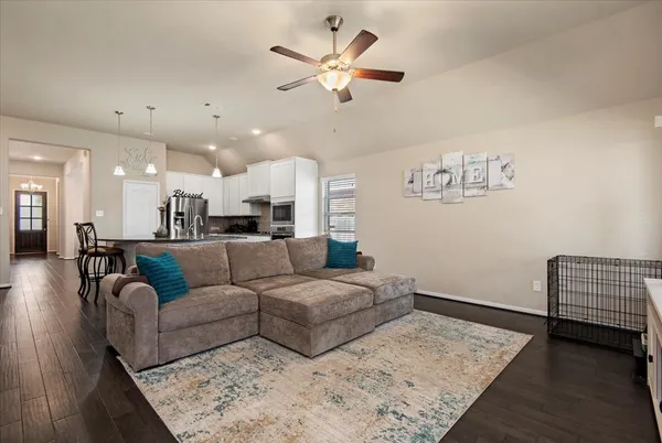 a living room with furniture and kitchen view