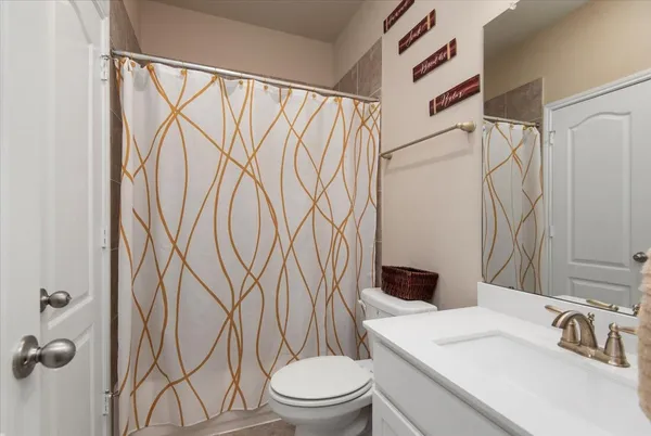 a bathroom with a shower curtain sink and a toilet