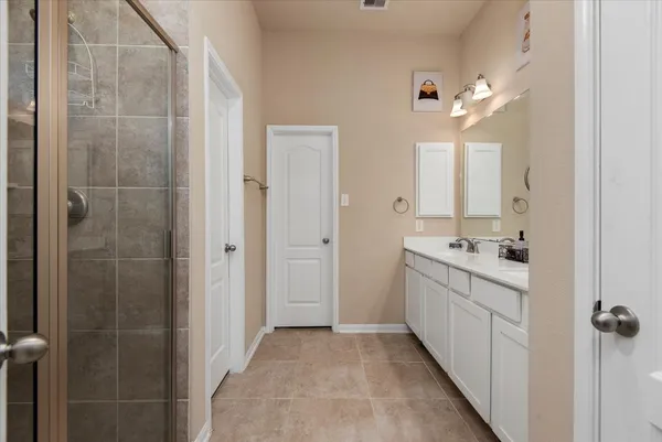 a bathroom with a double vanity sink a toilet and shower