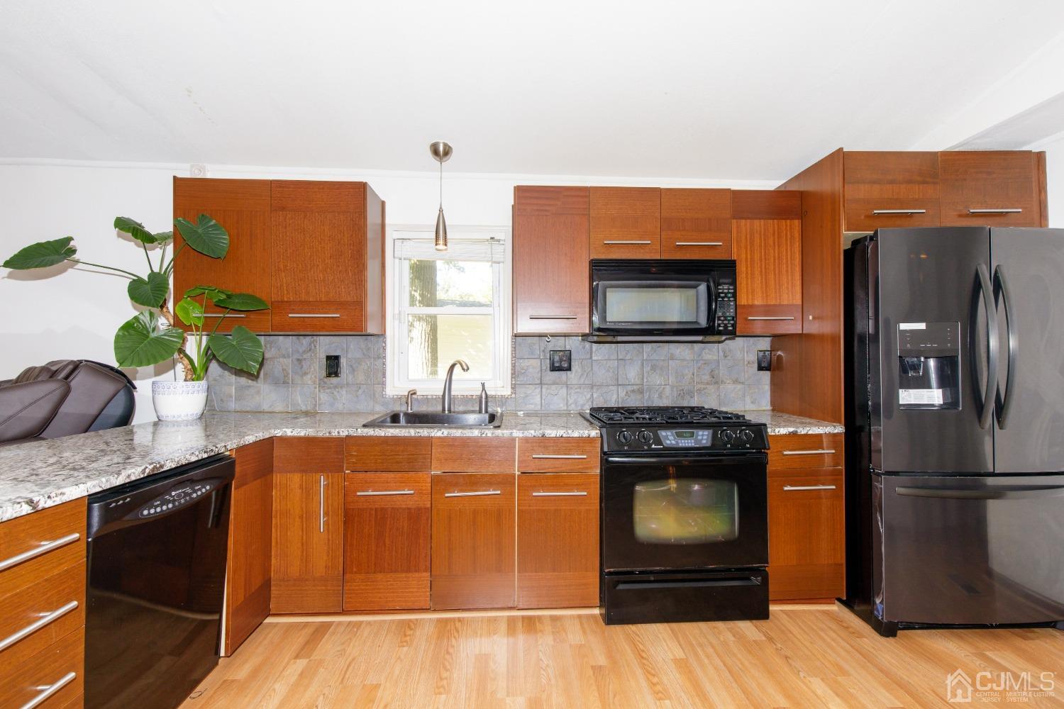 57 Burns Road North Brunswick, NJ 08902 - Photo 3 of 26 a kitchen with stainless steel appliances granite countertop a stove a refrigerator and a sink