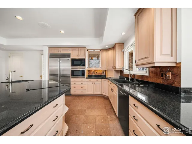 a kitchen with stainless steel appliances granite countertop a lot of counter space and wooden floors