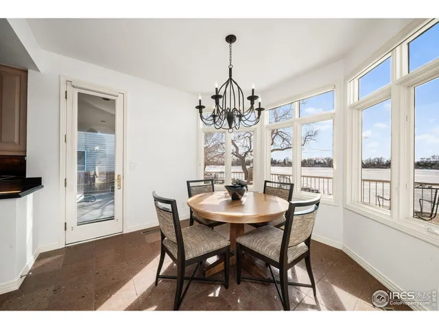 a dining room with wooden floor a chandelier a wooden table and chairs