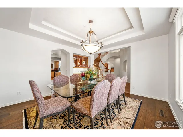 a view of a dining room with furniture a chandelier and wooden floor
