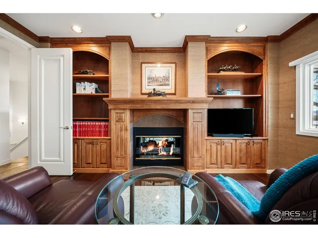 a dining room with wooden floor a chandelier a wooden table and chairs