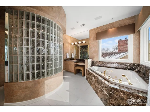 a bathroom with a tub a sink and a large mirror