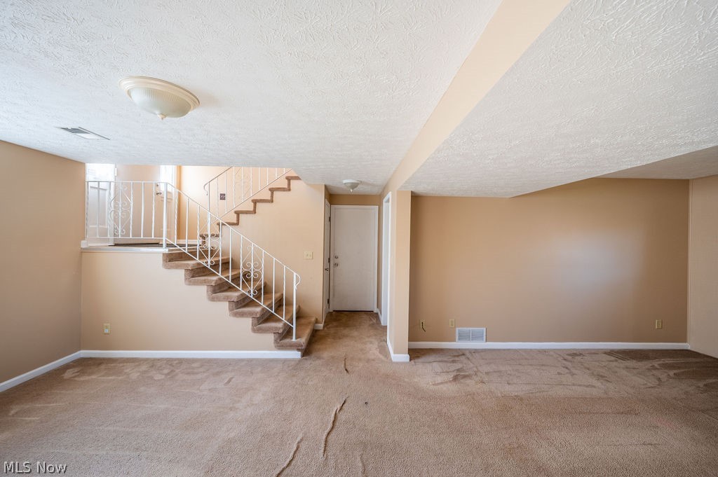 3601 River Road Vienna, WV 26105 - Photo 28 of 40 Finished basement featuring light carpet and a textured ceiling