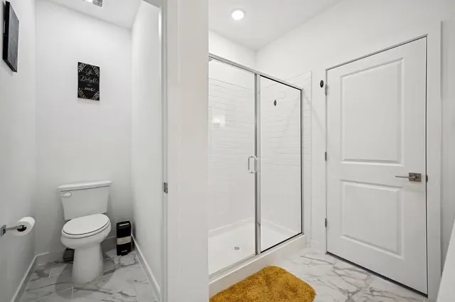 a bathroom with a toilet a sink and shower
