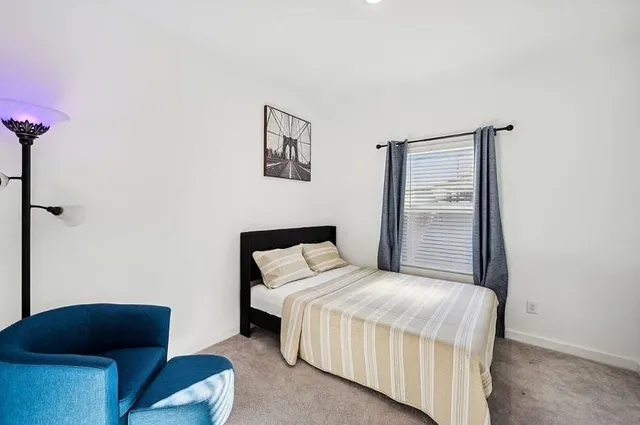 a bedroom with a bed and a chair