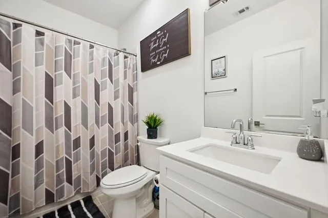 a bathroom with a granite countertop sink a toilet and a mirror