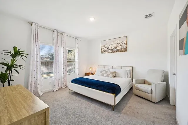 a spacious bedroom with a bed and a couch