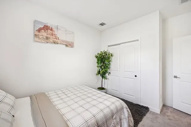 a bedroom with a bed and a potted plant