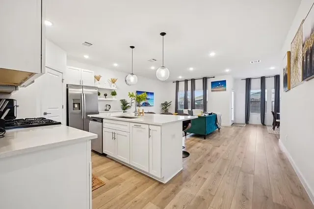 a kitchen with a sink a refrigerator and a wooden floor
