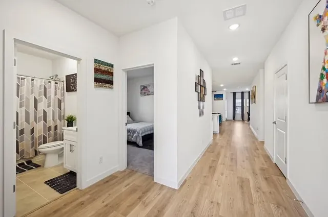 a view of a hallway with wooden floor and a living room