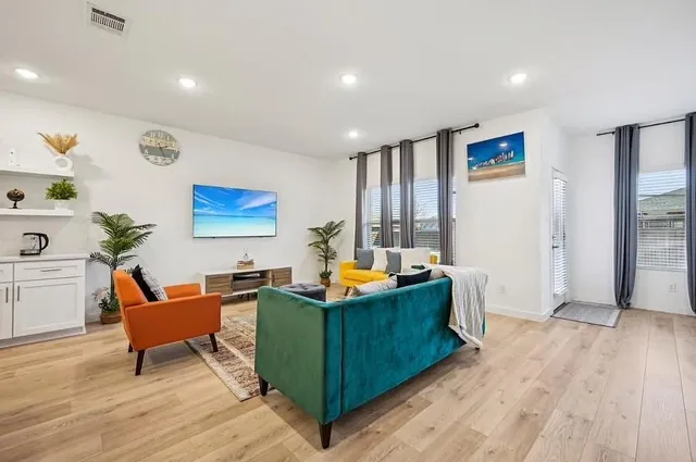 a living room with furniture and a wooden floor