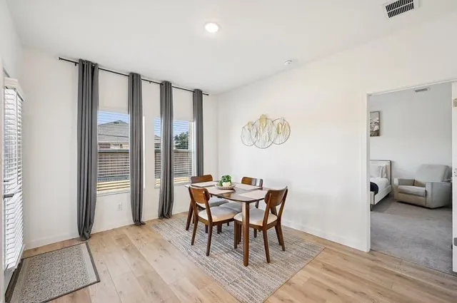 a dining room with furniture and wooden floor