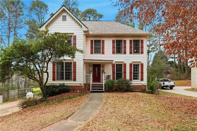 a front view of a house with a yard and trees