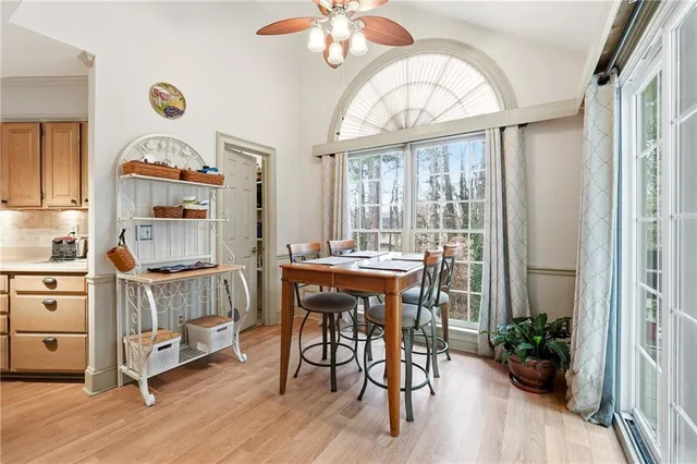 a dining room with wooden floor a chandelier a glass table and chairs