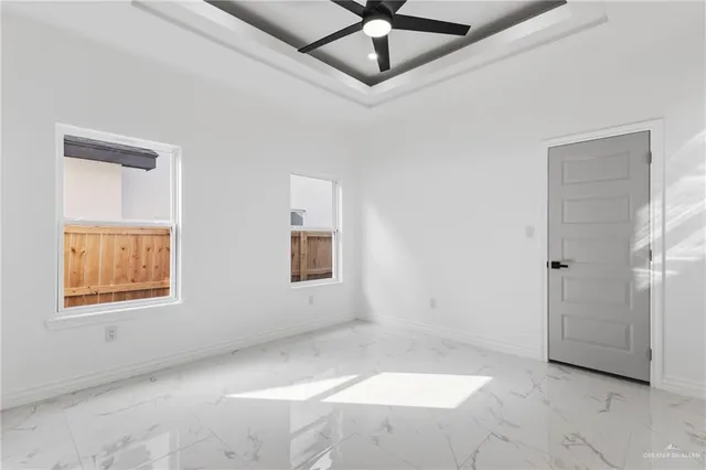 an empty room with windows and fan