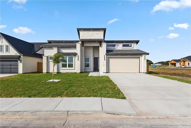 a front view of a house with a yard and garage