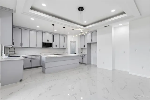 a large kitchen with stainless steel appliances lots of counter space and a sink